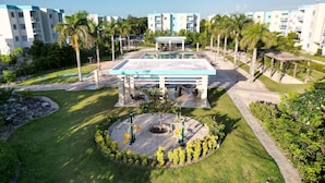 A hotel with a central courtyard, outdoor seating, and a pool area. - Luxurious Punta Cana Apartment Comfort, Convenience, and Caribbean Charm (Punta Cana)