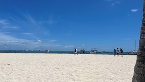A beach with people, boats, and a clear sky. - Luxurious Punta Cana Apartment Comfort, Convenience, and Caribbean Charm (Punta Cana)