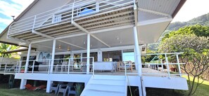 A multi-level building with a covered outdoor area, a balcony, and a view of greenery. - Villa Azura | On the edge of the lagoon and beach, with a view of Moorea (Paea)