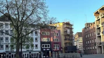 A cobblestone square with buildings, including a cafe and a building under construction.