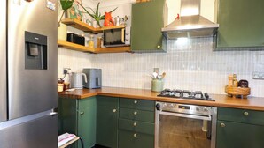 A kitchen with a stainless steel refrigerator, a microwave, a gas stove, and a built-in oven. - Farnham Park Apartment (Farnham)