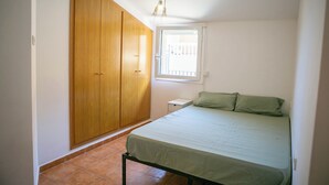 A bedroom with a bed, a wardrobe, a window, and a ceiling light fixture. - 2 bedroom apartment in the center of Begur (H08) (Begur)