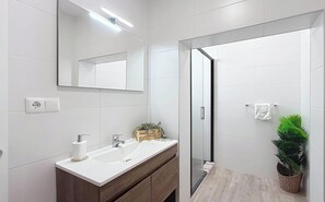 A modern bathroom with a white sink, mirror, and shower area. - Villa Almirante Torrecilla by South Costa (Nerja)