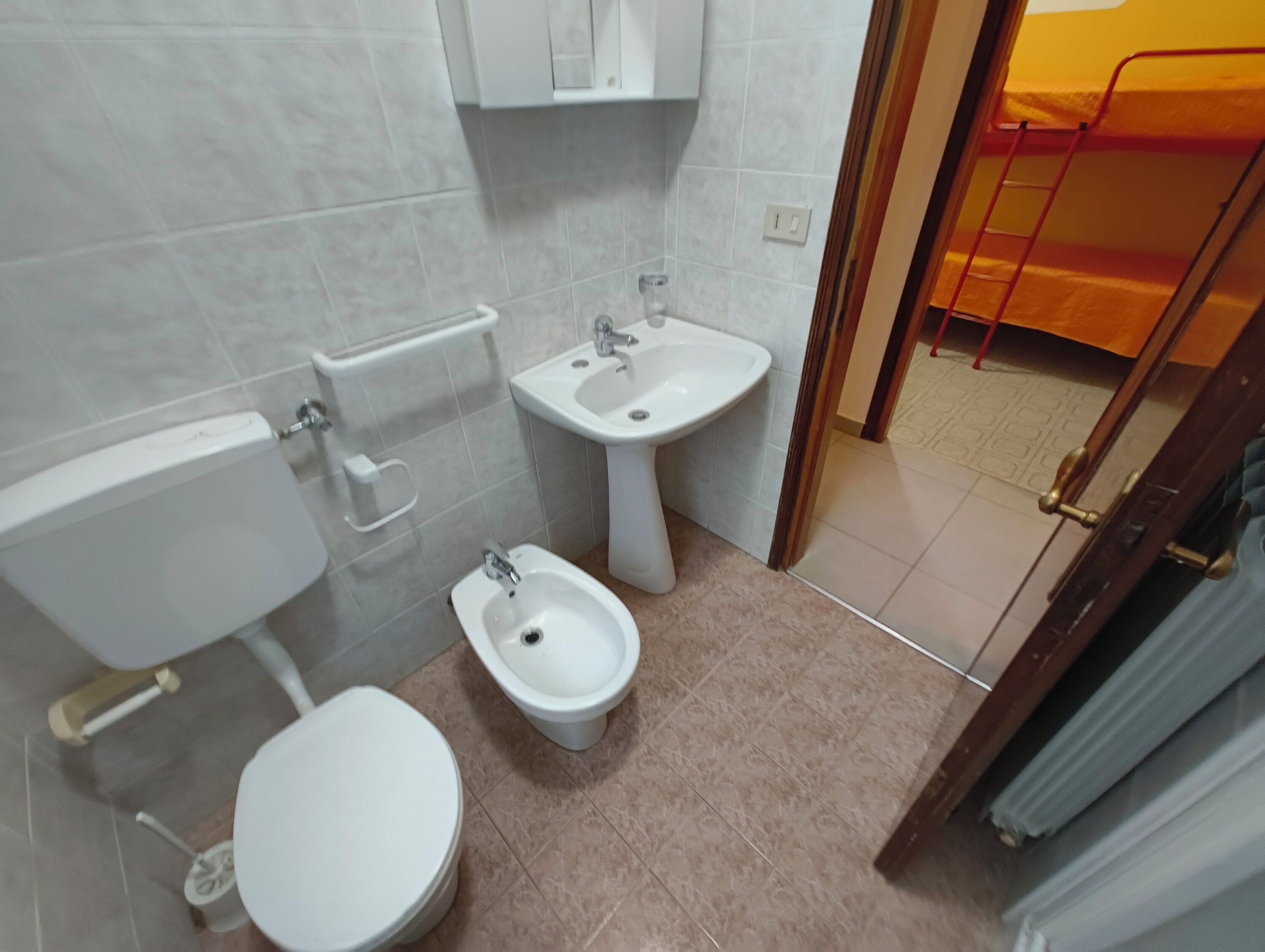 Un bagno con il water, un bidet e un lavandino.