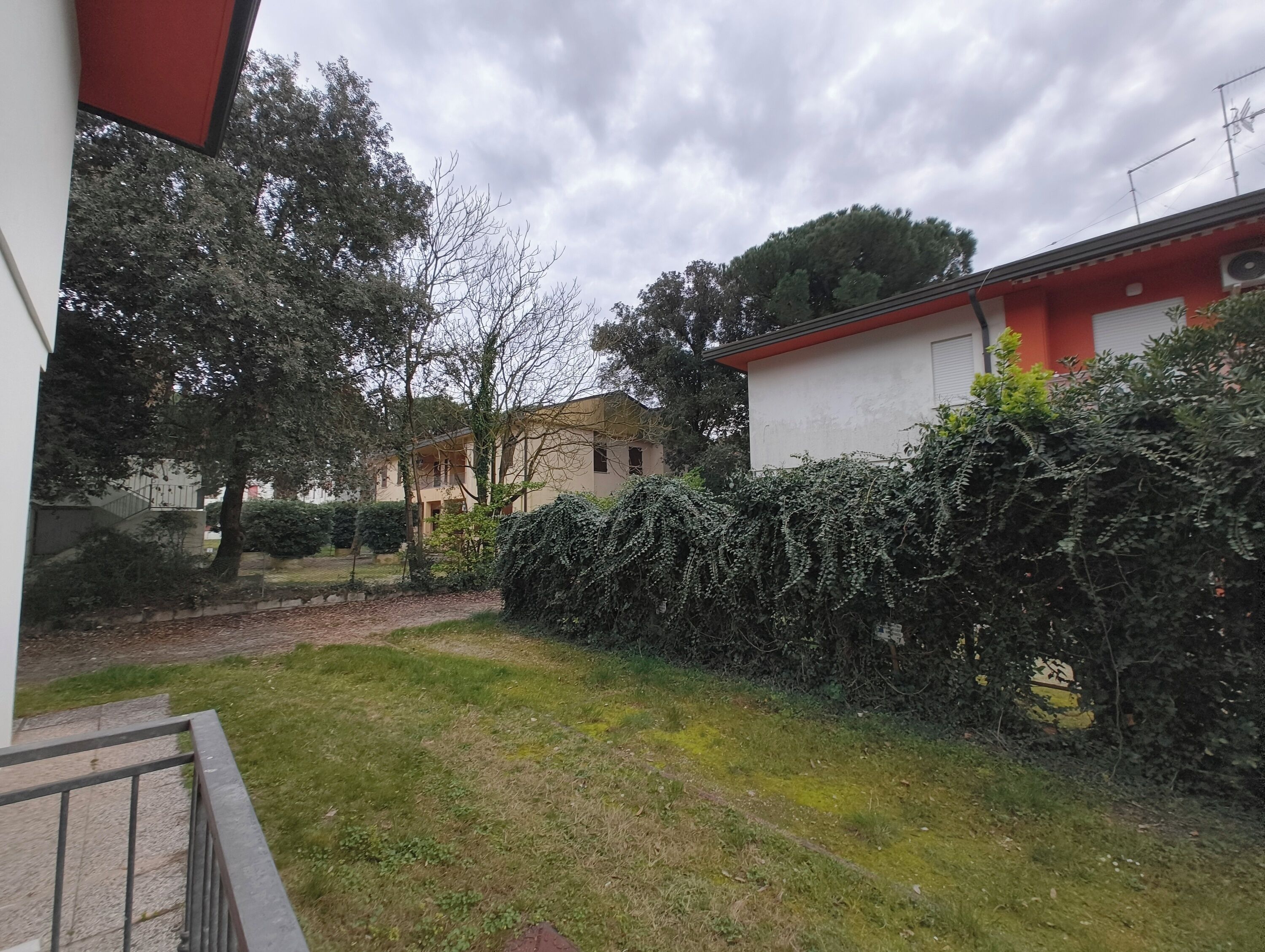Uma área residencial com uma casa, um jardim e um viveiro.