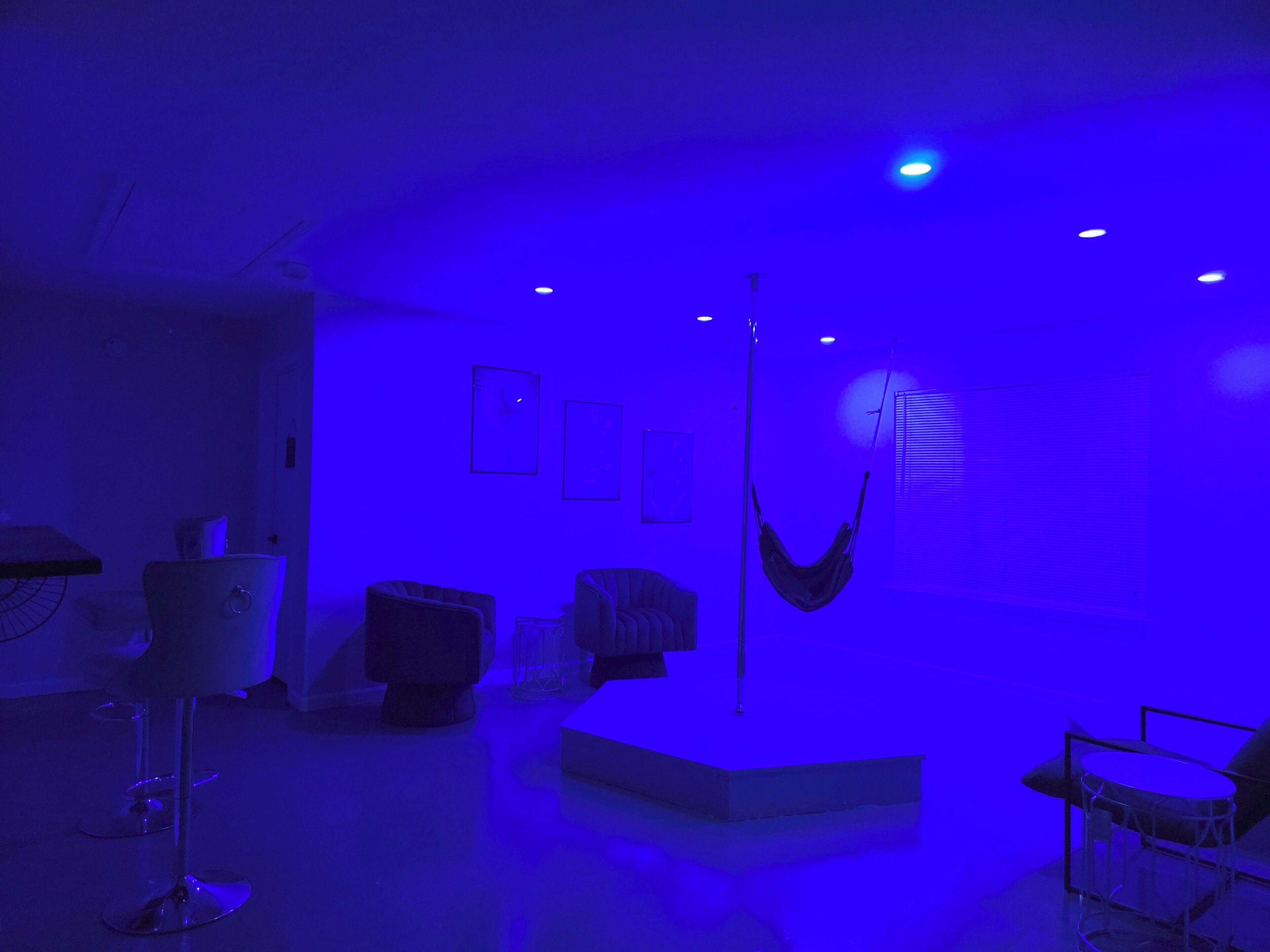 A room with a hammock, a glass table, and a chair.