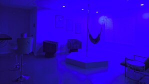 A room with a hammock, a glass table, and a chair.