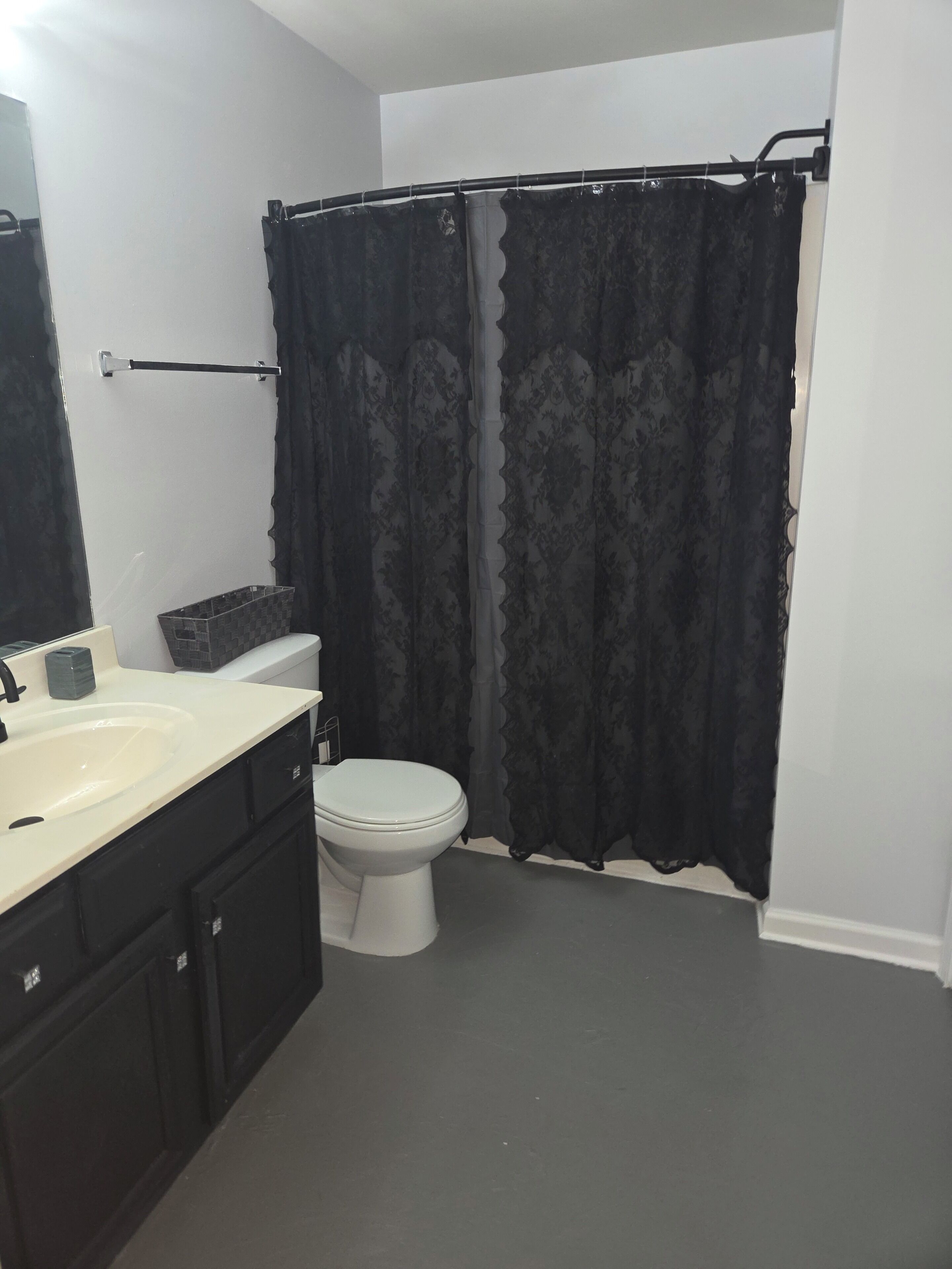 A bathroom with a toilet, sink, and mirror.