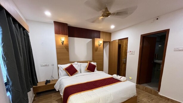 Ein Hotelzimmer mit Bett, Nachttischen, Deckenventilator und Holzboden.