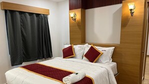 Ein Hotelzimmer mit einem Bett, Vorhängen, Wandleuchten und einer Holztür.