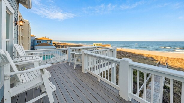 A wooden deck with white railings overlooking a beach. - Surf's Up (Carolina Beach)