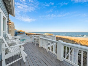 A wooden deck with white railings overlooking a beach. - Surf's Up (Carolina Beach)