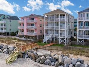 Une propriété située en bord de mer, avec des immeubles à plusieurs étages dotés de balcons et de passerelles en bois.