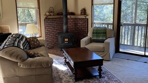 Ein Wohnzimmer mit Kamin, einer Couch, einem Sessel und einem Couchtisch.