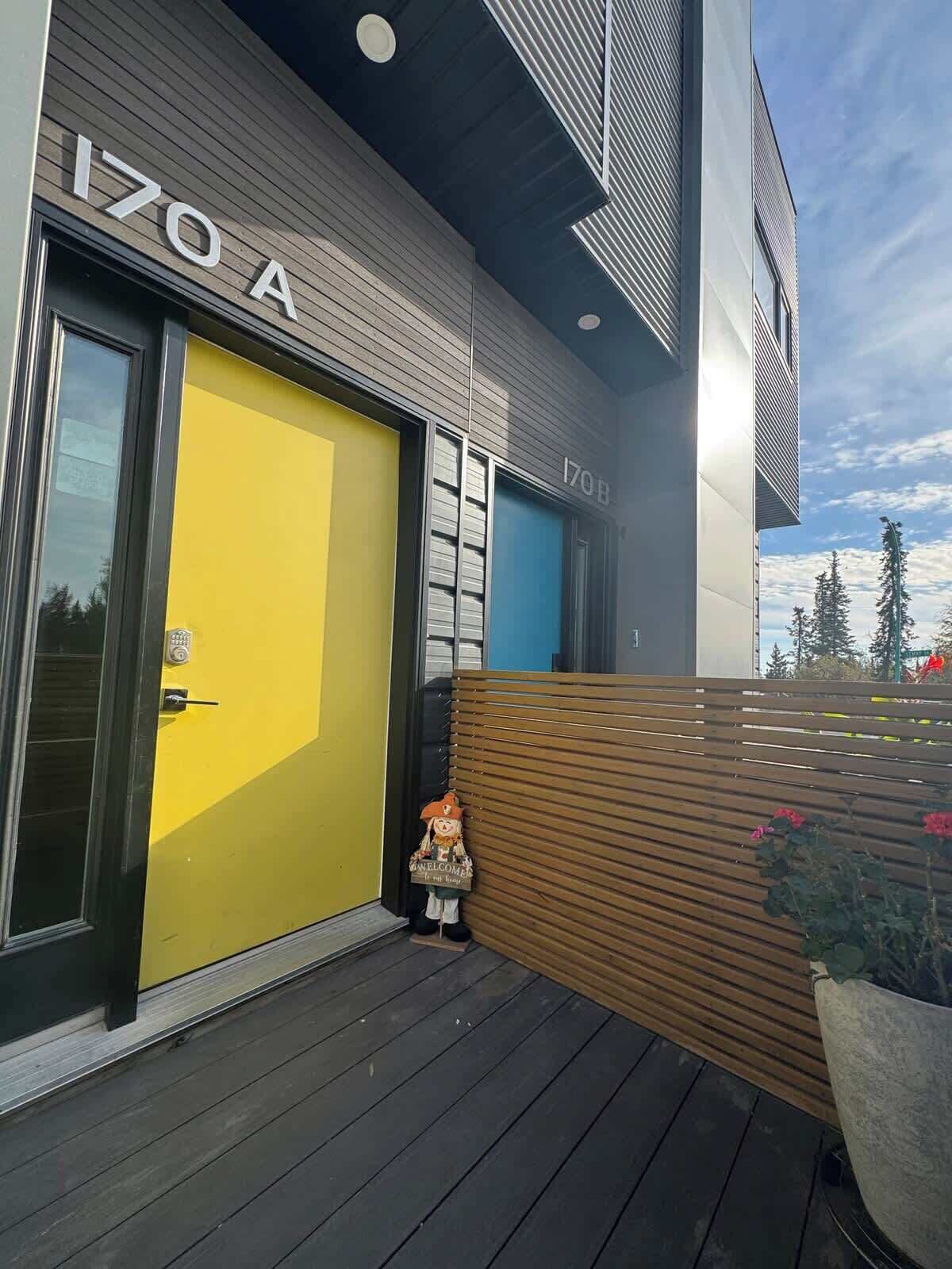 A modern building with a yellow door labeled '170 A' and a blue door labeled '170 B'.