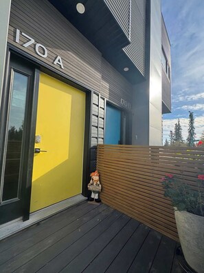 A modern building with a yellow door labeled '170 A' and a blue door labeled '170 B'. - Modern house with Aurora views (Yellowknife)