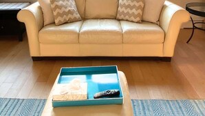 Un salon avec un canapé beige, une table basse et une vue dégagée grâce à de grandes fenêtres.