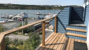 A wooden deck with a view of a marina and boats.