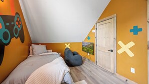 Ein Schlafzimmer mit einem Bett, einem Sitzsack, einer Tür und einer Wand mit einem Gebirgsmotiv.
