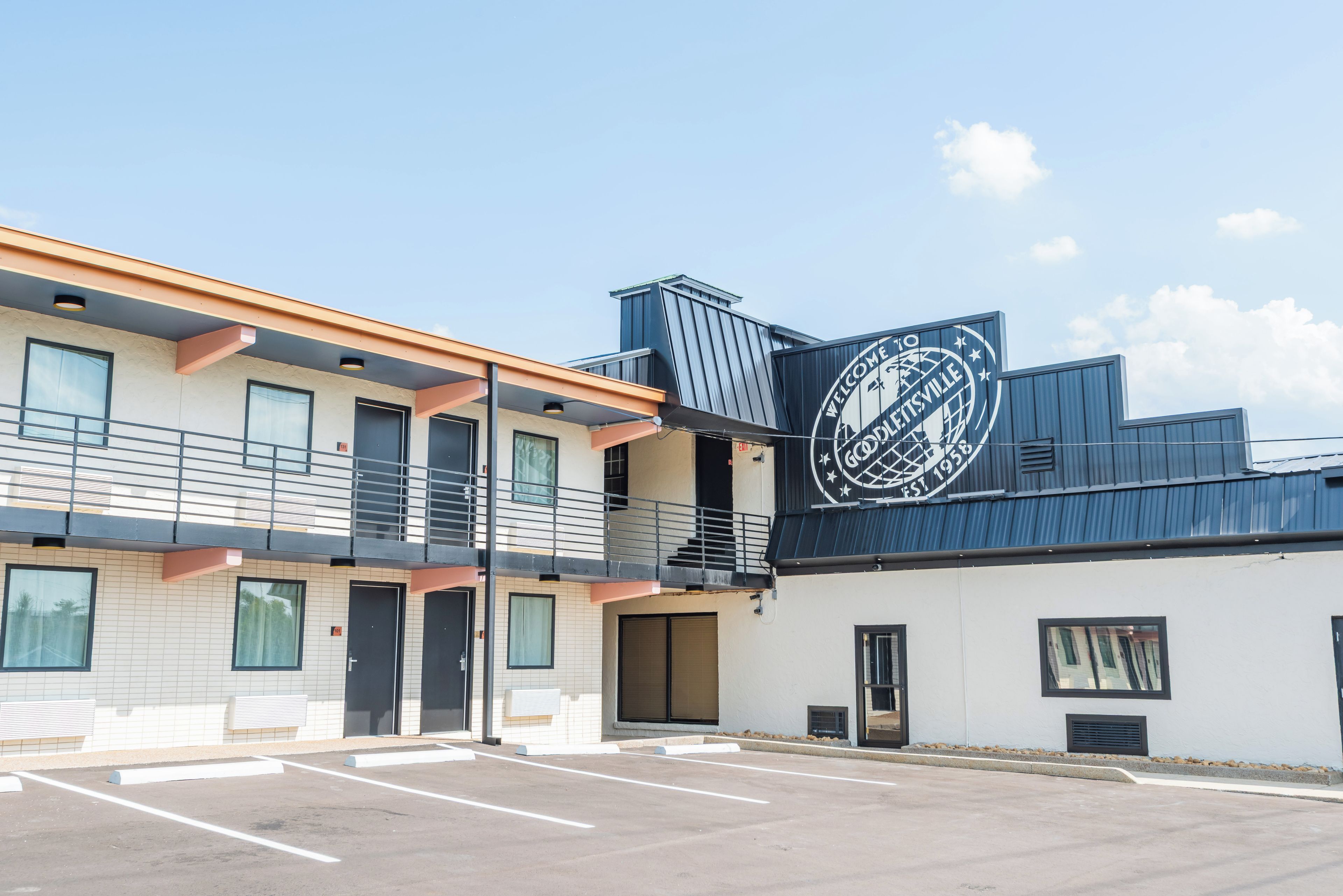 A two-story building with a parking lot in front.