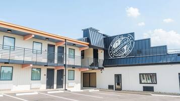 A two-story building with a parking lot in front.