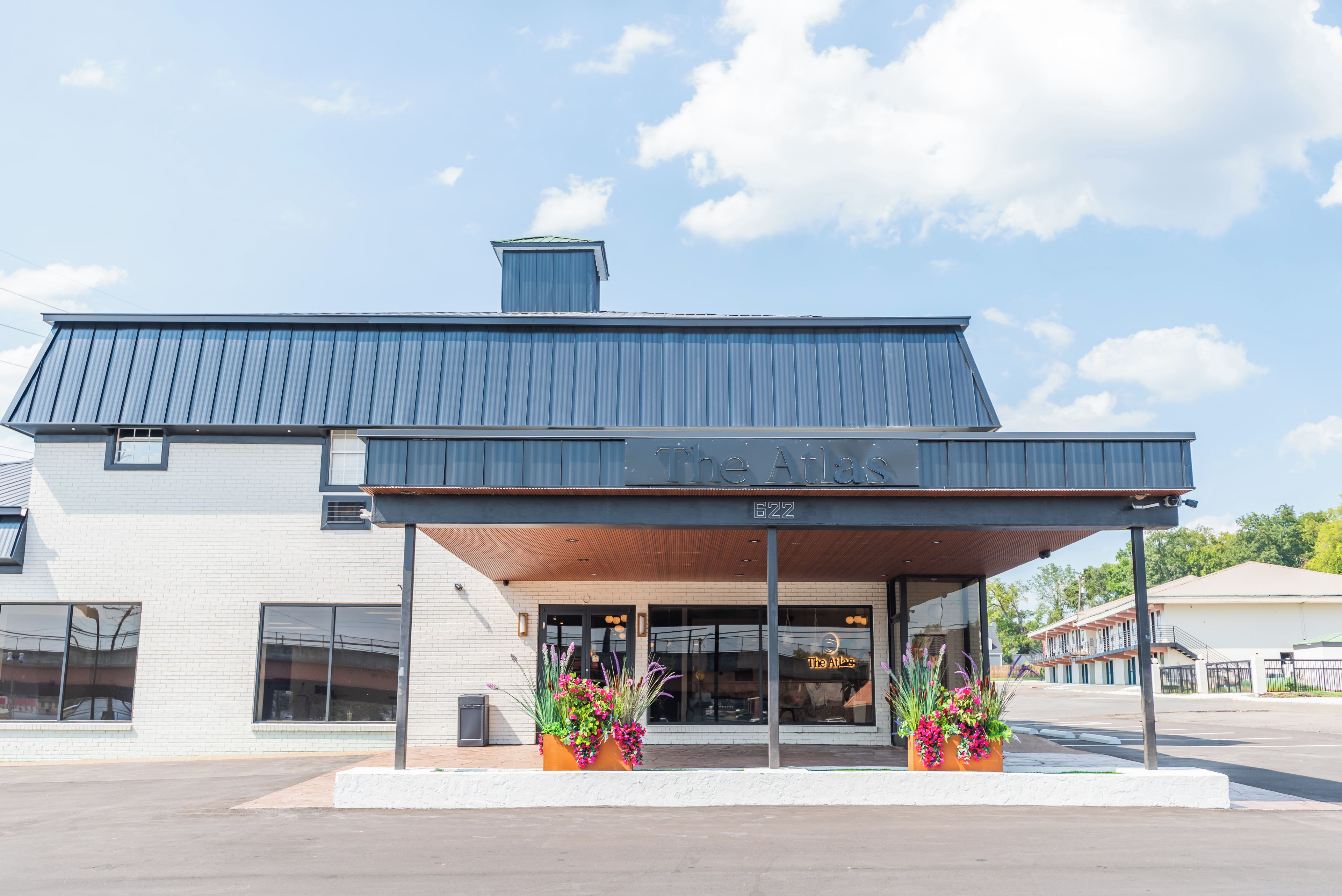 A building with a flat roof, a sign reading 'The Atlas,' and a number '622' on the facade.