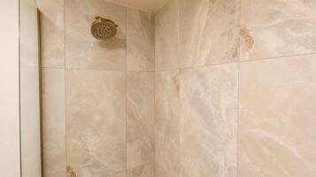 Habitación individual Deluxe, 1 cama King size | Baño | Regadera, toallas, jabón, shampoo