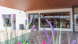 A modern building with a white brick facade, large glass windows, and a wooden ceiling. -  The Atlas Hotel & Lofts (Goodlettsville)