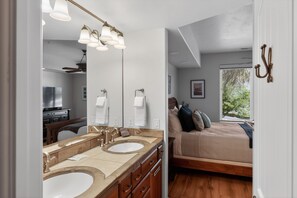 A bedroom with a bed, a large mirror, and a bathroom with dual sinks and a vanity. - 3BR Pet-Friendly Condo w/ Pool & Views (St. George)