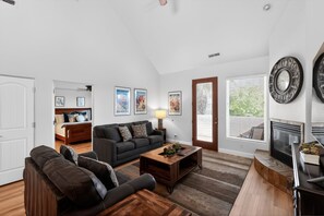 A living room with a sofa, coffee table, fireplace, and framed pictures on the wall. - 3BR Pet-Friendly Condo w/ Pool & Views (St. George)