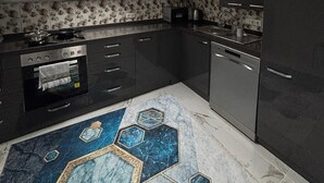 A modern kitchen with a skylight, dark cabinetry, and a patterned backsplash. - SC Apartments (Bad Goisern am Hallstättersee)