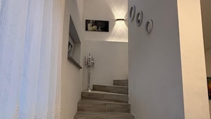 A staircase with a modern design, leading to a landing with a framed picture and wall-mounted light fixtures. - SC Apartments (Bad Goisern am Hallstättersee)