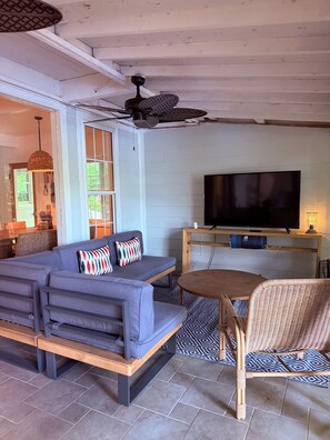 A living room with a grey sofa, a television, a ceiling fan, and a wooden table. - Lakefront Lake Lure Cabin: Private Dock, Paddleboards, Firepit Near Chimney Rock (Lake Lure)