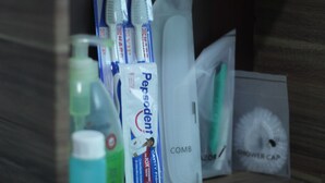 Casa de banho com suporte para escova de dentes, pente, touca de banho e frasco de enxaguante bucal.