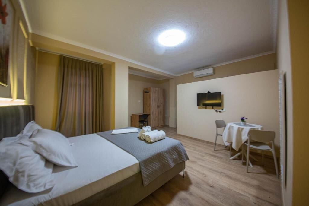 A hotel room with a bed, a desk, and a chair.