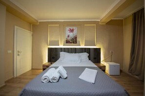 Een hotelkamer met een bed, nachtkastjes, een lamp en een schilderij aan de muur.