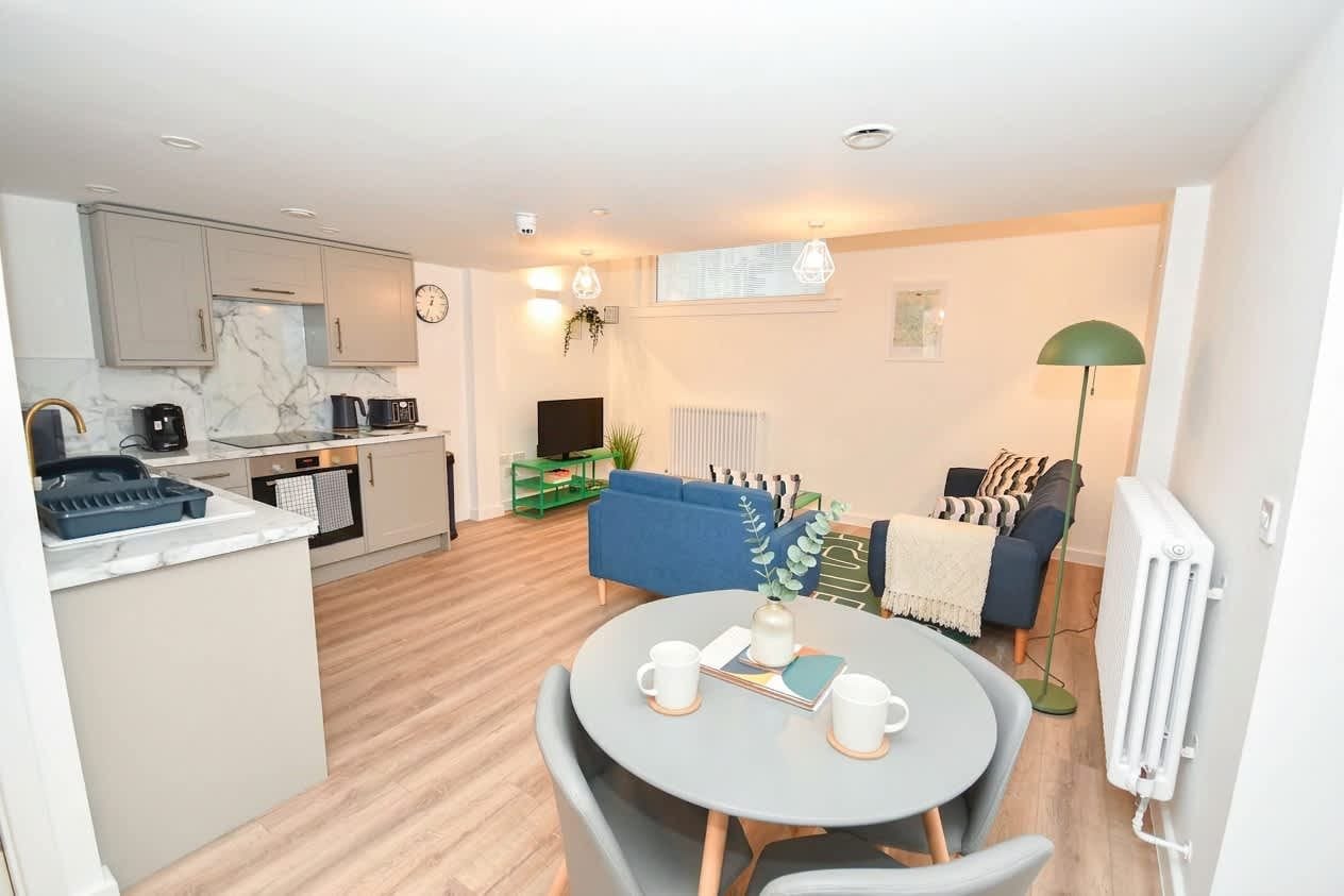 A modern apartment with a kitchen, dining area, and living room.