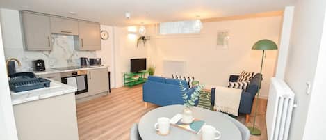 Um apartamento moderno com cozinha, sala de jantar e sala de estar.