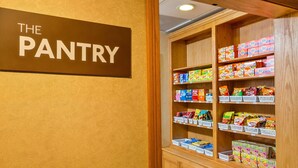 A pantry with shelves stocked with various snacks and boxed goods. - Brownsville Suite | Full Kitchen | Free Breakfast (Brownsville)