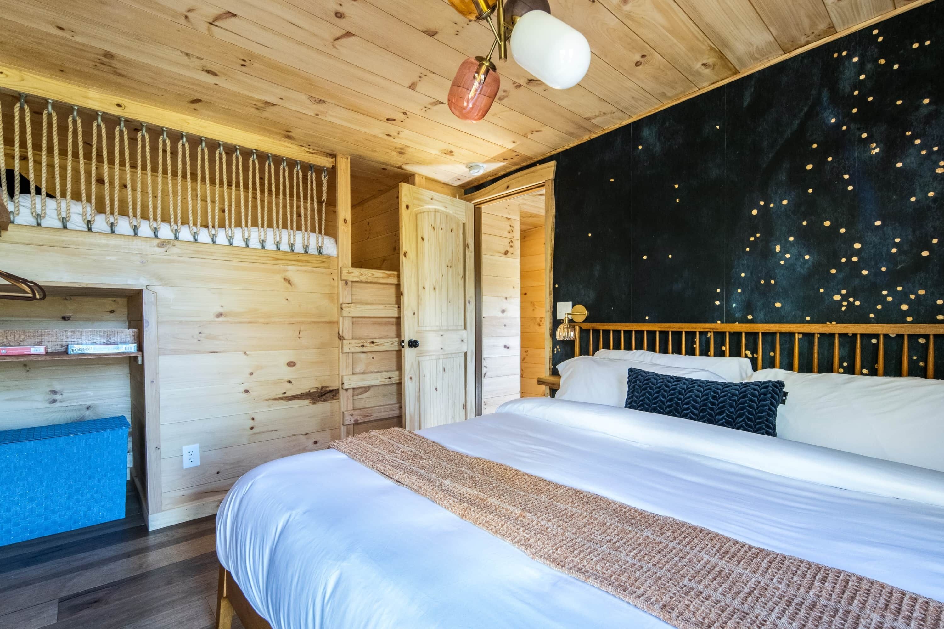 Una habitación de cabaña de madera con una cama, un armario y una barra para colgar ropa.