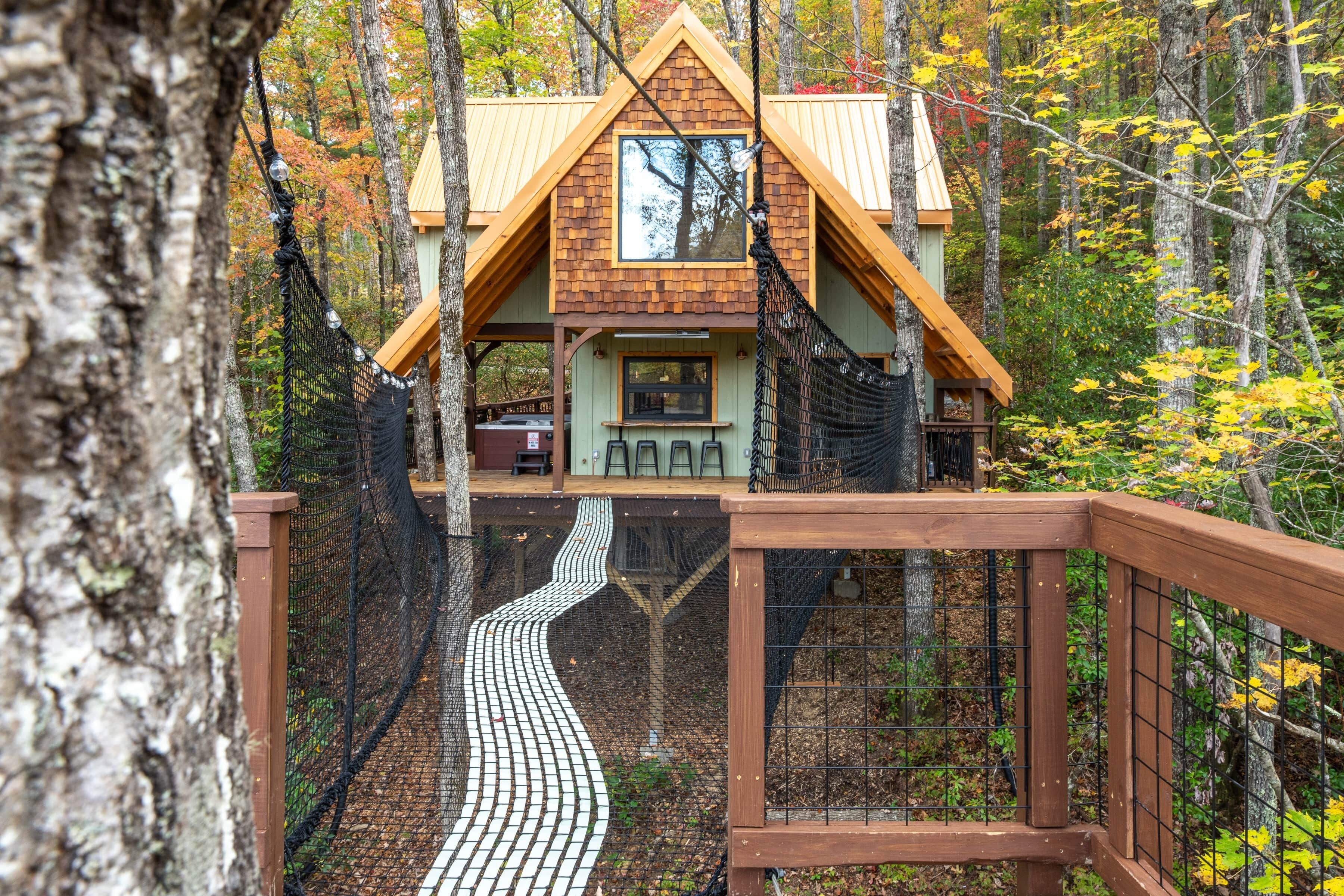 Une cabane en bois avec un toit en pente, une fenêtre et une terrasse.