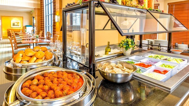 A buffet setup with various food items and a glass display case.