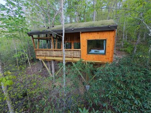A wooden treehouse with a balcony, built on stilts, surrounded by dense forest. - Nest-Shaped Cocoon Treehouse on 4 Trees - The Marsu (Highlands)