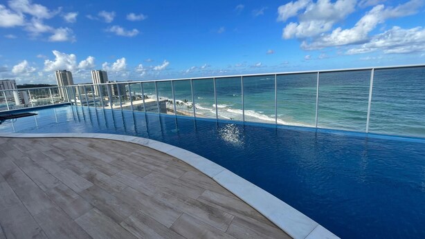 A rooftop infinity pool with a clear view of the ocean and city skyline. - Studio com vista Mar em Maceió - Max Rev (Maceió)