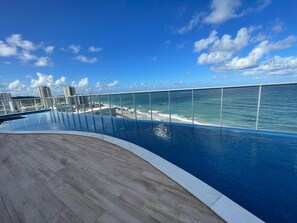 A rooftop infinity pool with a clear view of the ocean and city skyline. - Studio com vista Mar em Maceió - Max Rev (Maceió)