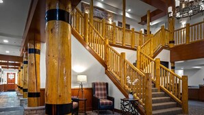 A grand staircase with wooden railings, a stone floor, and a chandelier. - Spacious 2-bedroom condo with Fireplace in majestic West Yellowstone (West Yellowstone)
