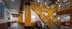 A grand staircase with wooden railings, a stone floor, and a chandelier. - Spacious 2-bedroom condo with Fireplace in majestic West Yellowstone (West Yellowstone)