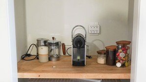 Une cuisine équipée d’une machine à café, de bocaux et de paniers.