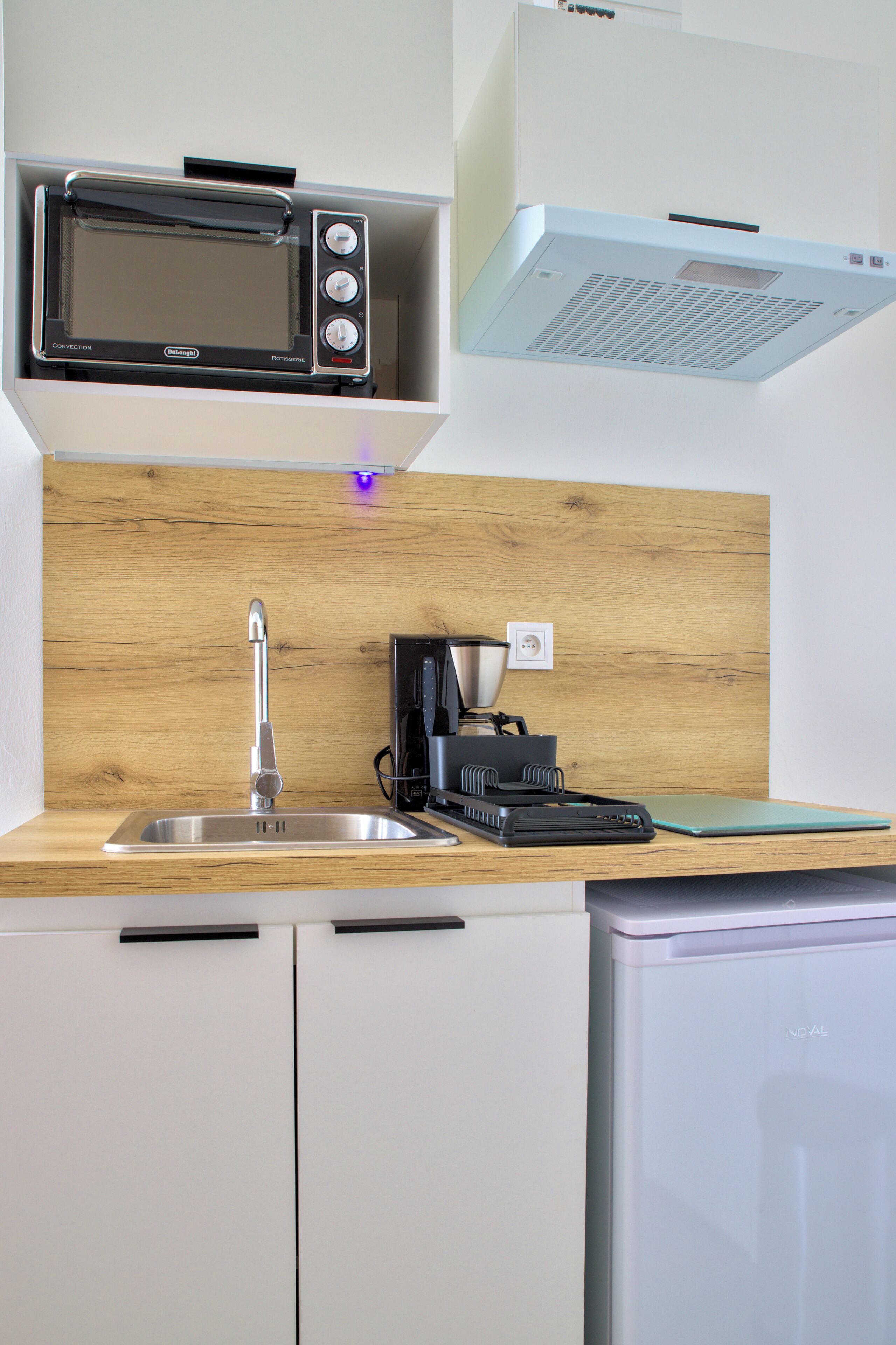 Una cocina equipada con microondas, tostadora, cafetera y lavavajillas.