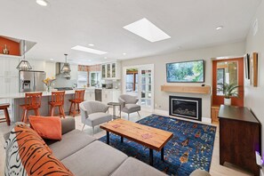 A modern living room with a sofa, a coffee table, and a fireplace. - South Oceanside Retreat 1.3 miles to the Beach! (Oceanside)